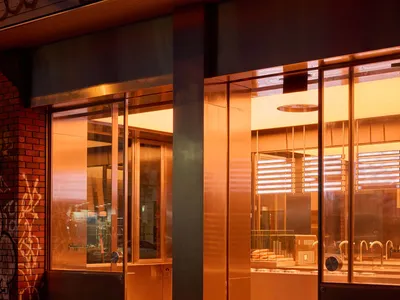 Welcoming store entrance with a glass door, a counter area, and two chairs, set in a pleasant and inviting atmosphere
