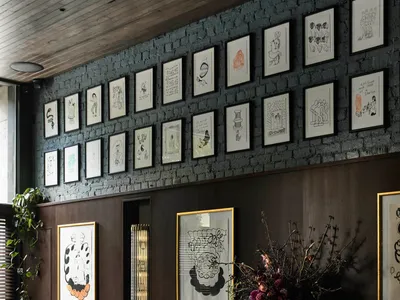 黑白室內設計展示空間，配有框裱藝術品、餐桌與盆栽