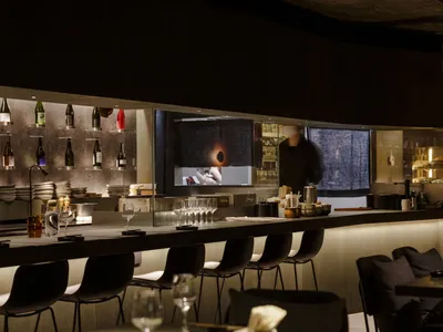餐廳酒吧場景，設有吧台、酒杯與環繞餐桌的椅子，散落酒瓶，營造溫馨氛圍