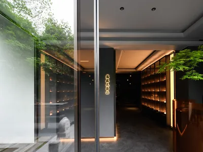 Modern hotel lobby with glass doors, cabinets, and a sense of openness and spaciousness