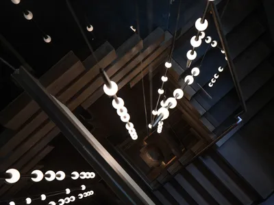 A modern hotel stairwell with wooden steps and lights, creating a well-lit atmosphere