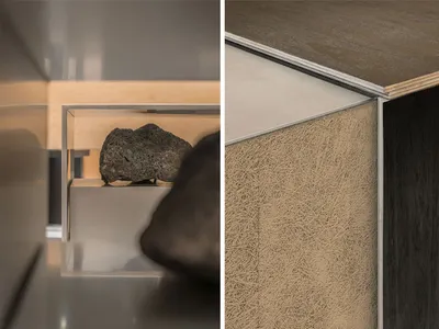 Cozy living space with a wood floor, carpeted area, and a glass case displaying rocks, with a couch present