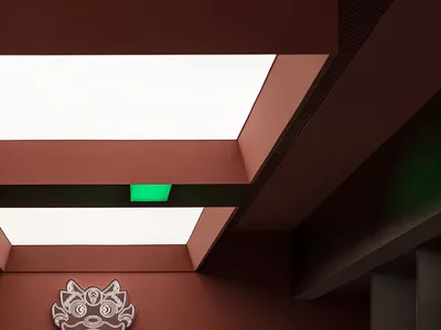 A modern restaurant interior with a red wall, green ceiling, and a counter with a logo, featuring two sinks and a refrigerator in a warm and inviting atmosphere