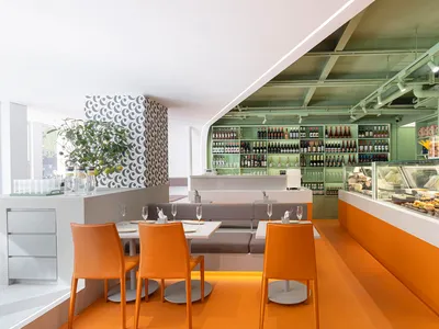 Warm and inviting dining space with an orange background, a large wooden dining table, and wine glasses on the table
