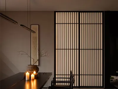 A dining area with a black table and chairs, candles, and vertical blinds, conveying elegance and sophistication