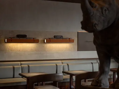 A restaurant interior with a large rhinoceros statue as its centerpiece, surrounded by multiple chairs in an elegant and inviting atmosphere