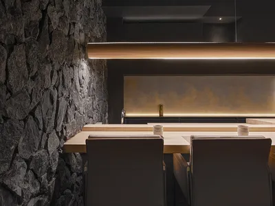 現代廚房內配有長形木質餐桌，周圍環繞座椅，營造出適合聚會用餐的溫馨氛圍