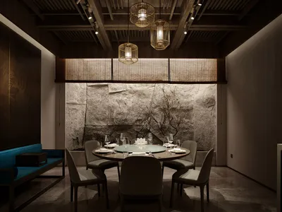 Dining area with a round table, stone walls, and fine china and wine glasses