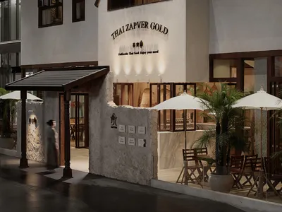 Inviting indoor shopping area with a storefront, chairs, and dining tables, featuring a Thai Zapper Gold sign