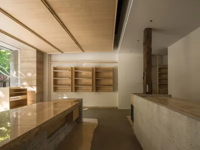 Modern kitchen with wooden cabinets and shelves, well-lit with natural light from windows