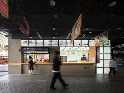 現代餐廳場景，設有吧台與座位區，一位穿西裝的男子走向吧台，展示瓶裝飲料與杯具