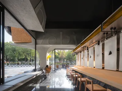 一間休閒餐廳，設有大型餐桌環繞座椅、溫暖燈光，以及木質與金屬元素的混搭
