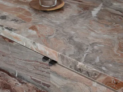 A modern kitchen with a marble countertop, sink, and cup, featuring a luxurious and sophisticated design