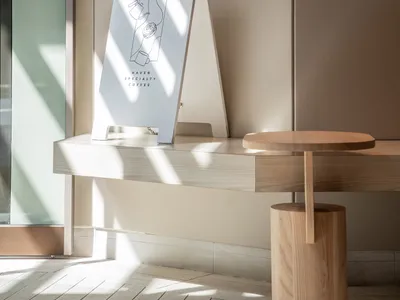 A warm and inviting interior design showroom with a wooden table, two chairs, and a cozy atmosphere
