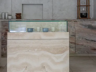 A clean and organized interior design showroom with a marble countertop display, featuring three cups and a luxurious ambiance