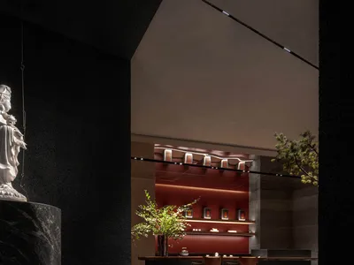 Dark room with a black marble countertop, vases, and multiple chairs, creating a luxurious and stylish atmosphere