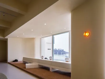 Open living area with a leather sofa, two chairs, a dining table, and natural light from a window