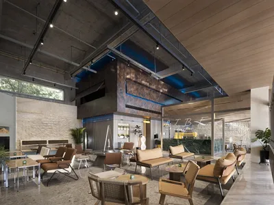 A spacious open area with seating options, wood, and metal elements, featuring potted plants and an inviting atmosphere