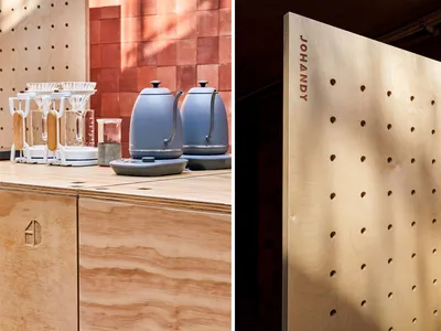 Modern kitchen design featuring wooden countertops, a coffee maker, and a decorative pegboard wall