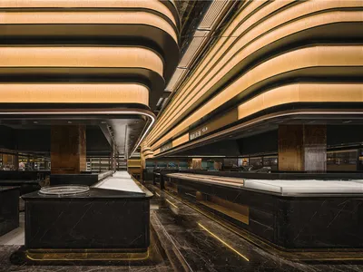 Elegant hotel lobby with a marble countertop, surrounded by seating areas and warm lighting