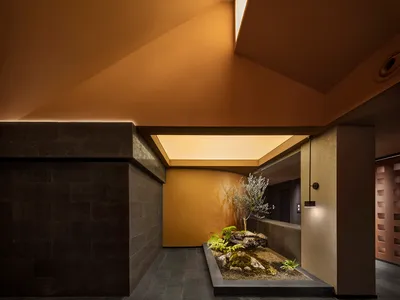 溫馨客廳空間，配有餐桌、椅子與盆栽，設有水槽並營造溫暖氛圍