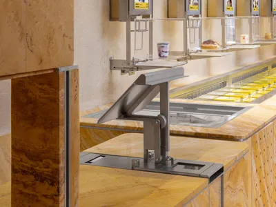 An inviting ice cream shop with a marble counter displaying various flavors of ice cream in cups, surrounded by a warm and enticing atmosphere