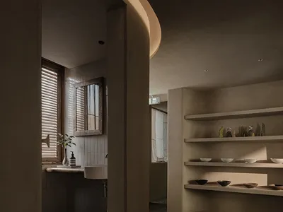 Dimly lit bathroom with tile walls, a sink, a mirror, and decorative vases