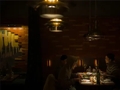 一群人在溫暖親切的亞洲餐廳環境中共同用餐，配有餐桌、椅子、酒杯及各式餐具