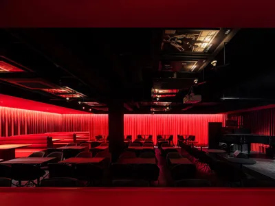 溫馨現代餐廳內部，紅色牆面、黑色餐桌與各式座椅，營造出溫暖的氛圍