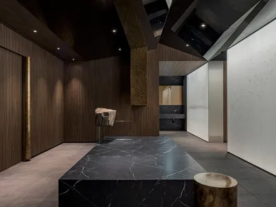 A modern kitchen with a black marble countertop, two sinks, and a contemporary design, giving an elegant and luxurious atmosphere
