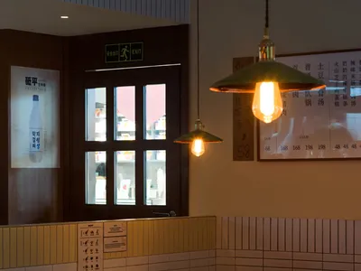 溫馨亞洲餐廳內部，設有長餐桌、馬賽克磚牆與懸吊燈光