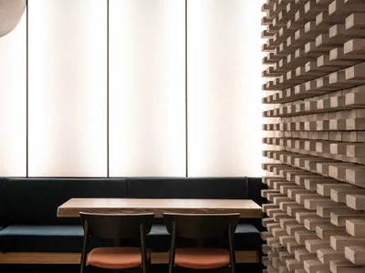 Spacious restaurant interior with two dining tables, white walls, and modern chairs