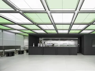 工業風廚房配黑色檯面、雙水槽與現代家電，背靠大片窗戶