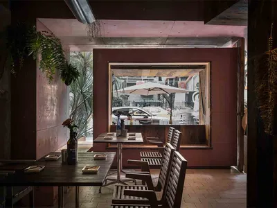 Dining area with tables, chairs, umbrellas, and wine glasses in a restaurant with a relaxed atmosphere
