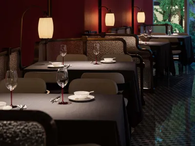 Elegant restaurant interior with red walls, black tables, and wine glasses, creating a sophisticated atmosphere