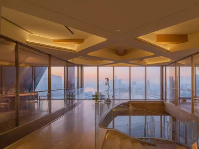 A bright and inviting hotel lobby with a glass staircase, natural light, and a modern design