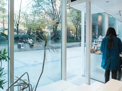 A casual indoor cafe with a variety of seating options, multiple counters, and people enjoying their time