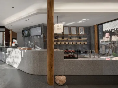 A modern Asian restaurant interior with a counter, wood elements, and well-lit space with bottles and cups on display