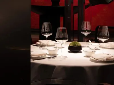 現代餐廳區域，為特殊場合擺設餐桌，配有酒杯、碗盤與花瓶，周圍環繞時尚室內設計