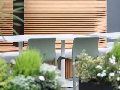 Warm and inviting dining space with wooden walls, a table, and two chairs, featuring a logo on the wall
