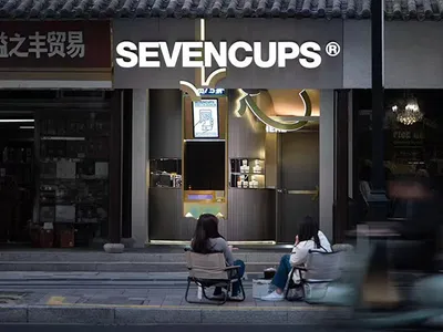 兩位女子在木質元素的溫馨亞洲餐廳戶外享用飲品
