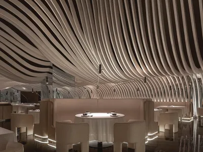 A modern restaurant interior with multiple dining tables and chairs, creating a comfortable and inviting atmosphere for guests