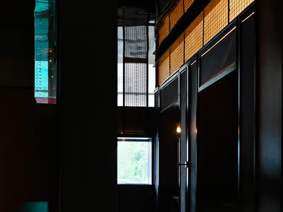 Elegant hotel lobby with a large window, two chairs, and a dining table, featuring natural light and inviting atmosphere