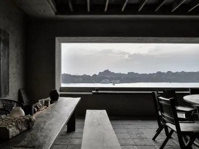 燈光明亮的餐廳空間，配有餐桌、椅子與裝飾品，背景有船隻圖案，營造溫馨舒適的氛圍