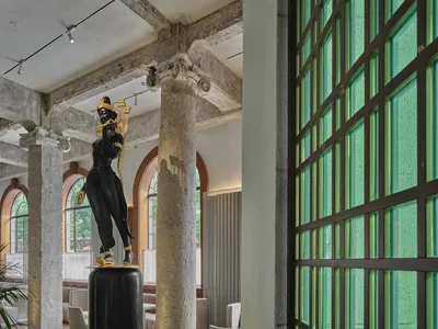 優雅室內空間，配有座椅、餐桌與雕像，融合功能與美學