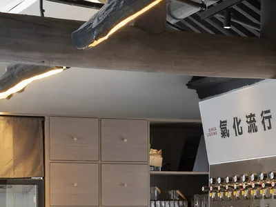A lively Asian restaurant bar with numerous beer taps and bottles, and scattered cups, inviting customers to enjoy a variety of drinks