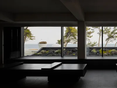 窗前擺放桌椅的明亮餐廳，面向寬闊海景大窗，完美適合邊用餐邊欣賞美景
