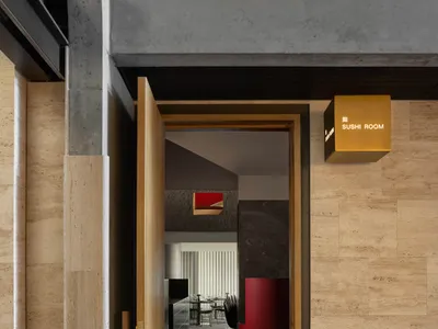 Modern restaurant interior with black flooring and walls, wooden doors, chairs, and a clock on the wall