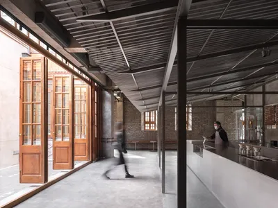 Spacious modern restaurant and bar space with dining tables, chairs, and high ceilings