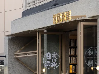 Modern Asian restaurant with a counter, chairs, and books, creating a cozy atmosphere